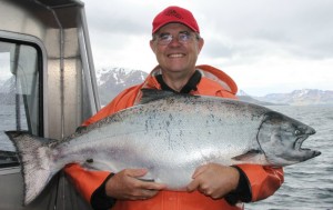 Man holding large king salmon on a boat in Alaska