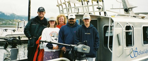 Family fishing vacation on a boat with guide at the dock in Alaska
