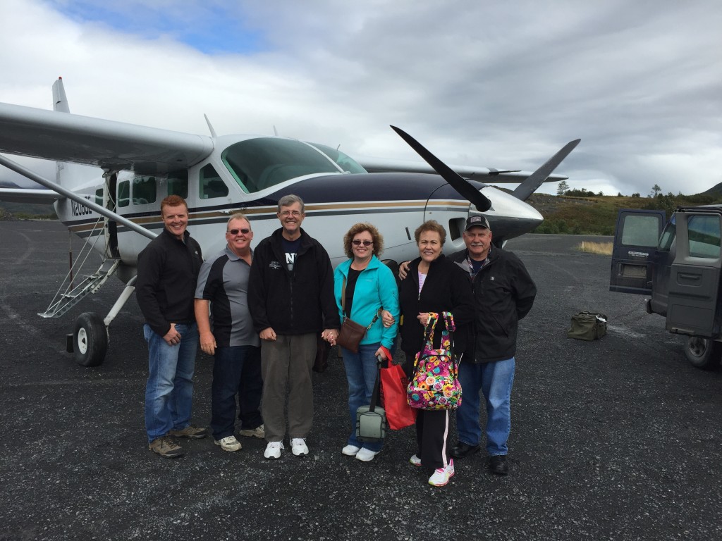 Travel Expert Lisa with Group of men and women standing in front of small aircraft on tarmac